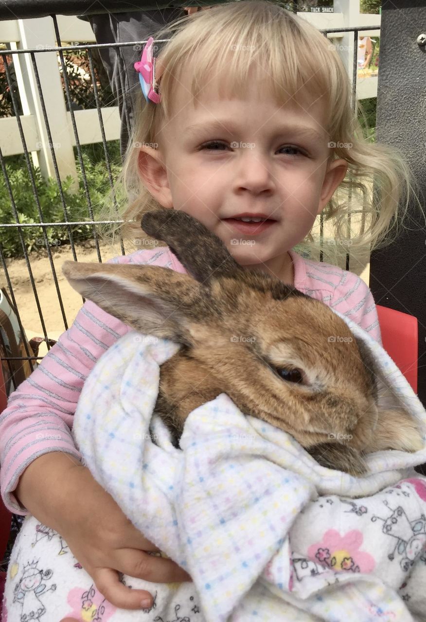 Little girl holding a big sweet bunny 