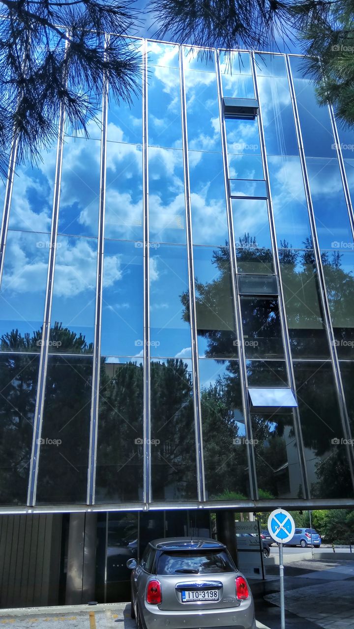 Reflection of the summer sky on a glass building in Athens