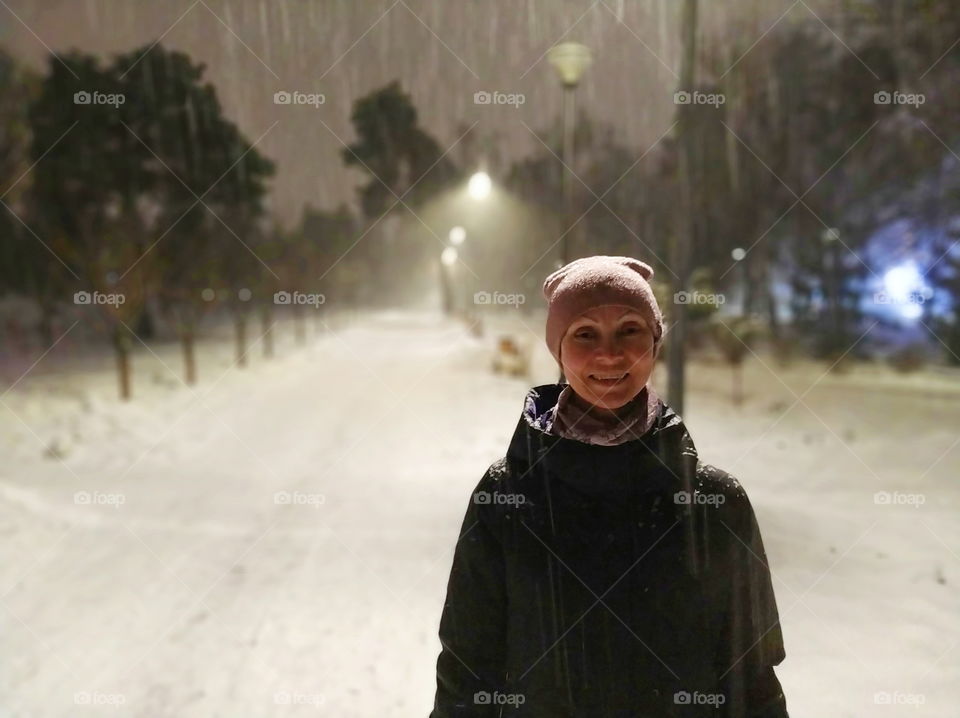 one girl in an empty park on a winter evening in the city of Kiev