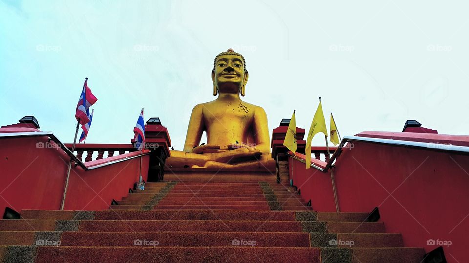 Great golden Buddha statue is smiling  to photographer.