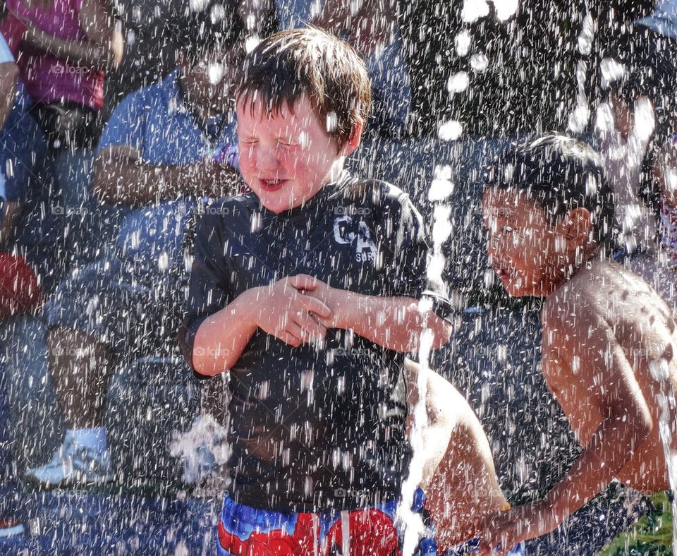 Boy Splashing In A Fountain. Cooling Off In The Summertime