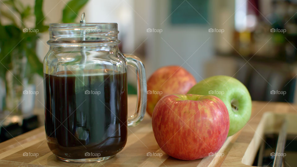 Healthy red and green apples on wood table in kitchen next to fresh black coffee in glass mug conceptual healthy choices And self care tranquil lifestyle background photography
