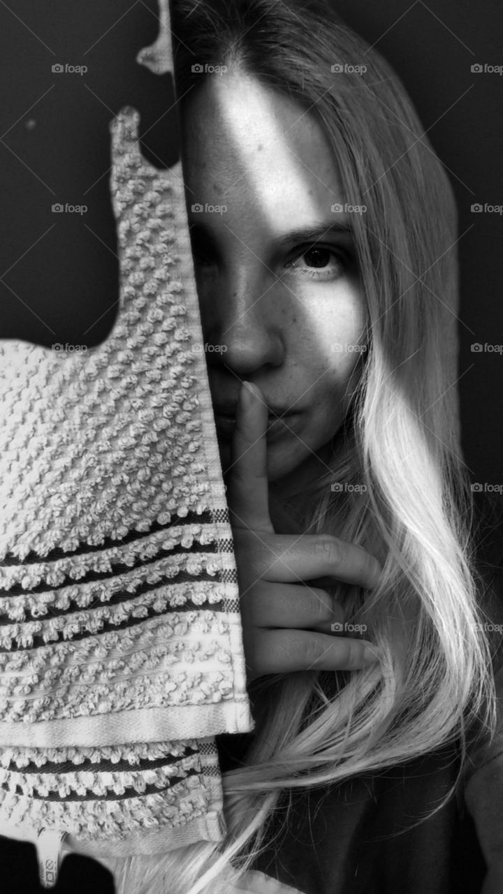 black and white photo of a girl who mysteriously stands in the shadows