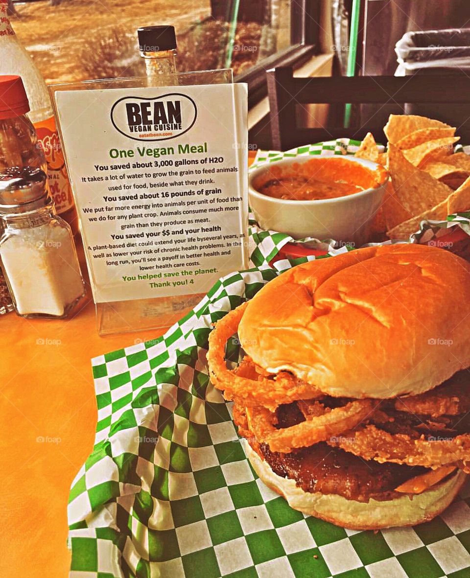 Bean Vegan’s “Cowboy Burger” with Seiten bacon, Daiya cheddar, onion rings, pickles, BBQ sauce, and ranch dressing.