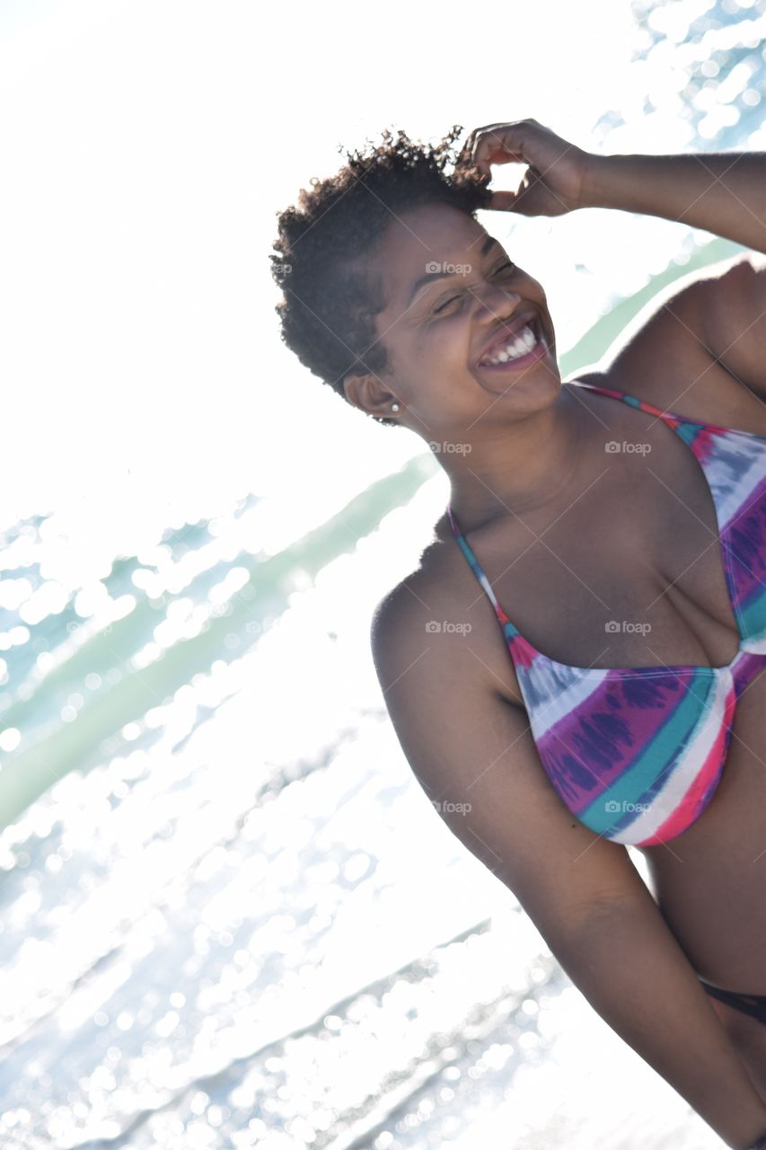 Smiling african woman in bikini at beach