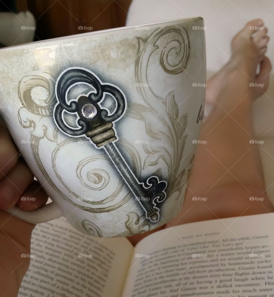 my favorite spot at home stretched out on the couch with a cup of coffee or tea in my favorite family is the key mug and a good book in my lap with bare feet just enjoying my life