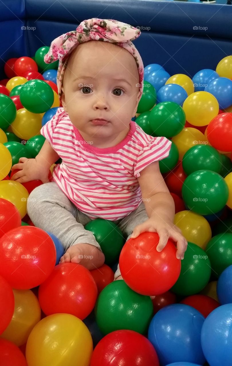 baby girl plaing in the ball pit