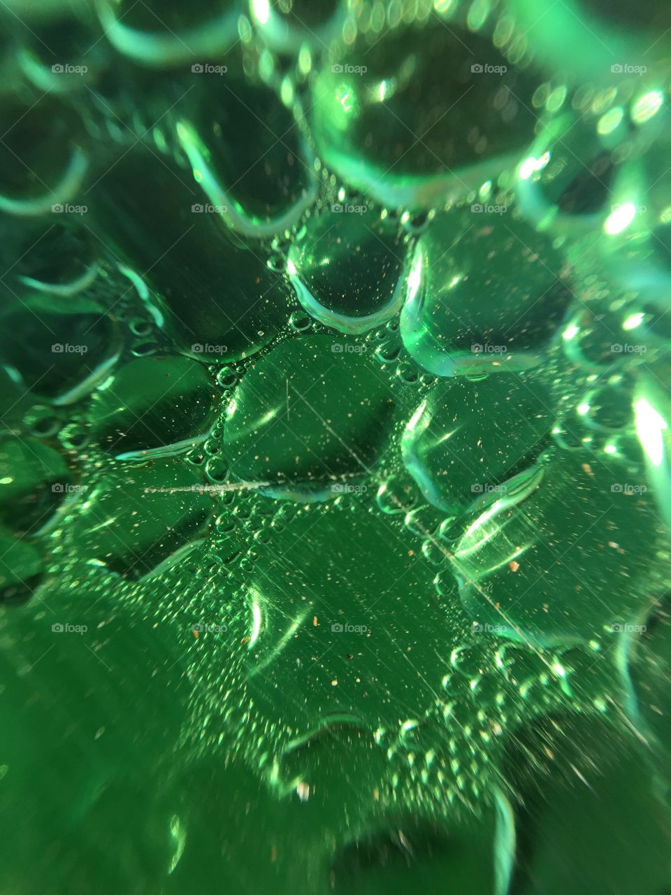 Macro water droplets on a green plastic bottle