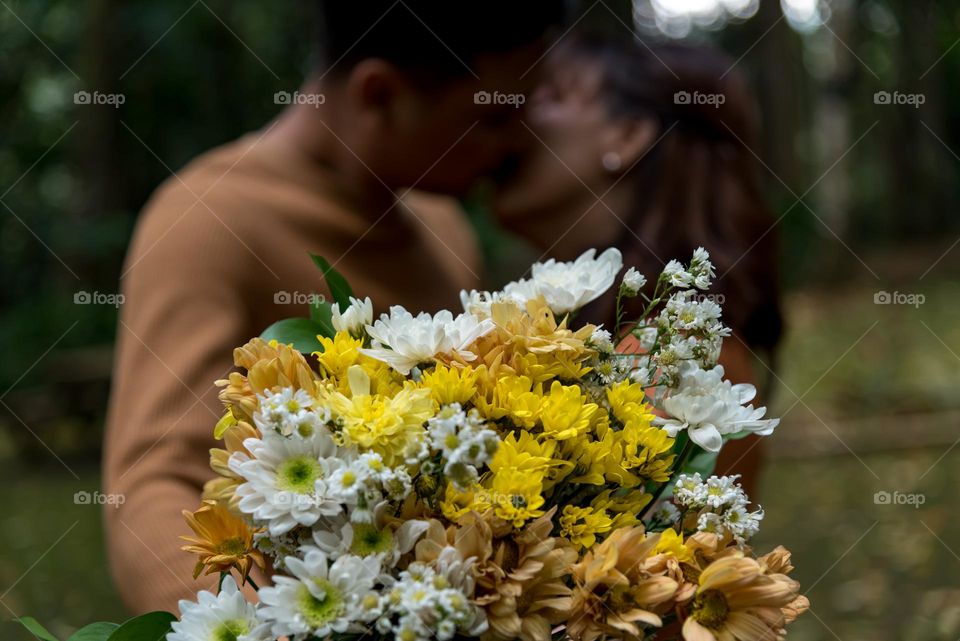 A couple kisses in middle of a jungle