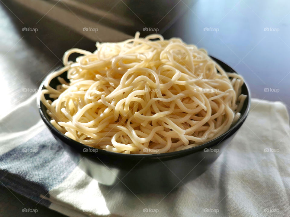 Chow mein without ingredients on a black bowl.