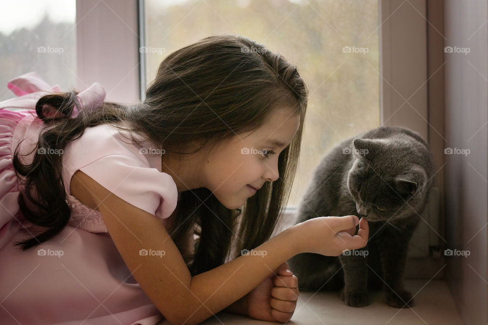 Close-up of a cute girl with her cat