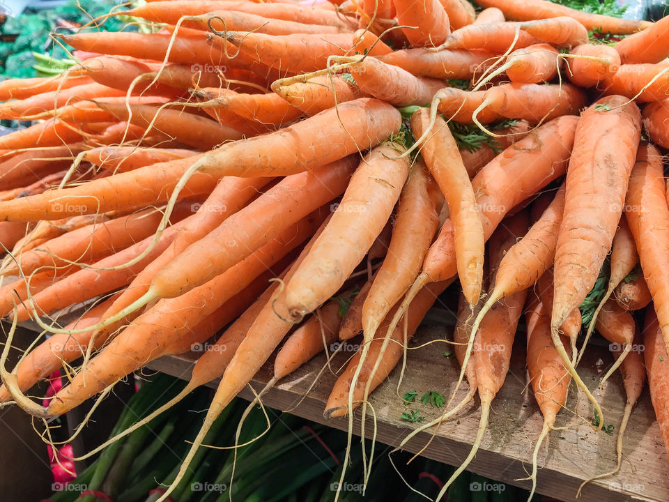 Heap of fresh harvested orange colored carrots ready for sale at farmers market