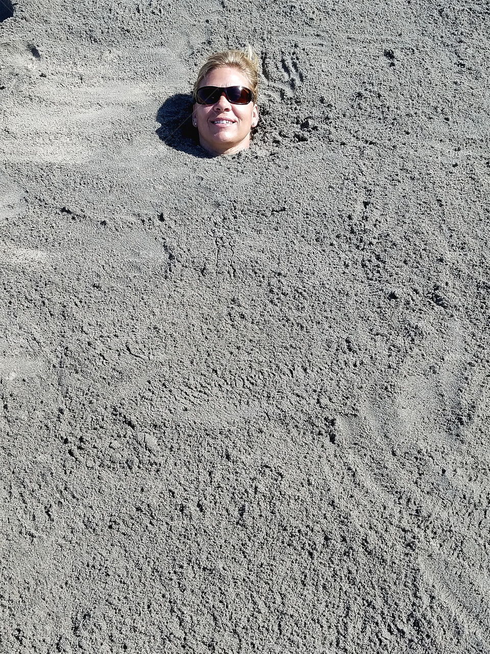 Head of a woman buried in sand