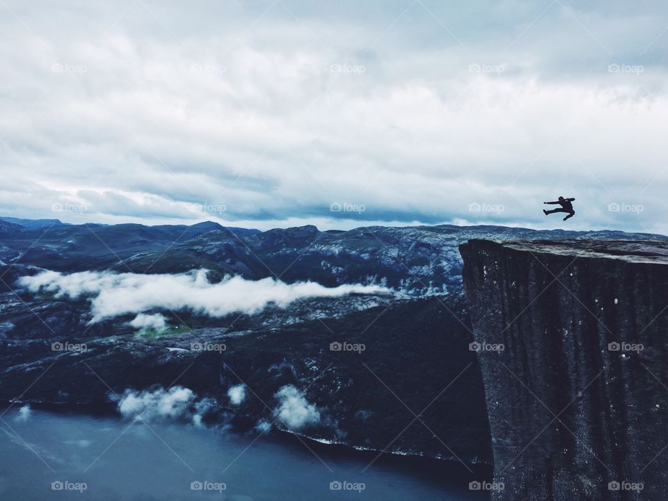 Person jumping on cliff