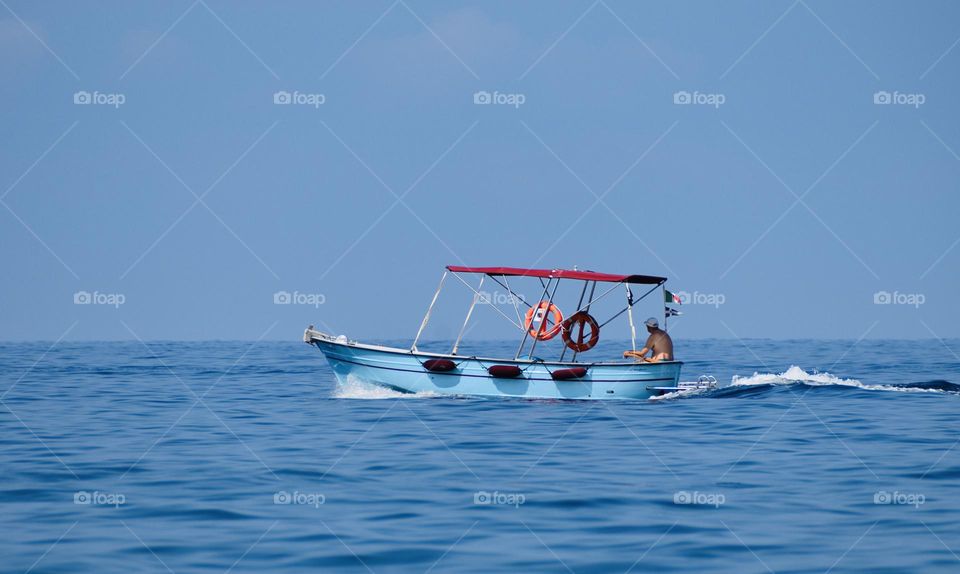 Boat sailing on calm blue seawater 