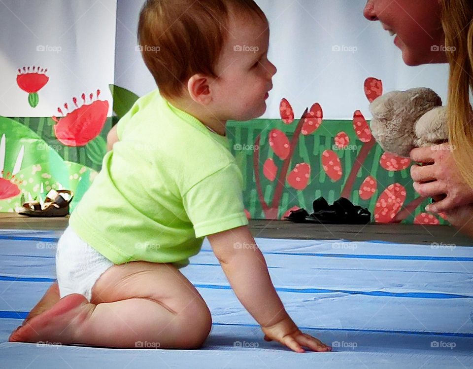 Happiness. A smiling little boy in a diaper and a smiling mother sit opposite each other on the podium. The happiness of motherhood Photo from which the beholder has a smile on his face and happy emotions