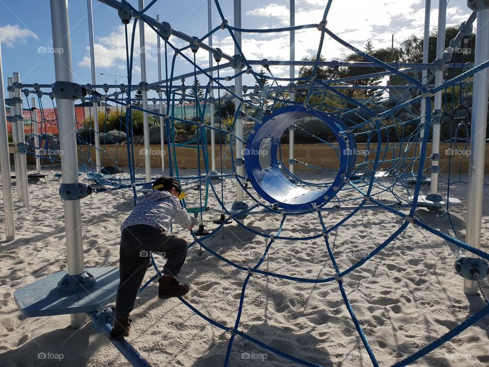 boy climbing on playground equipment