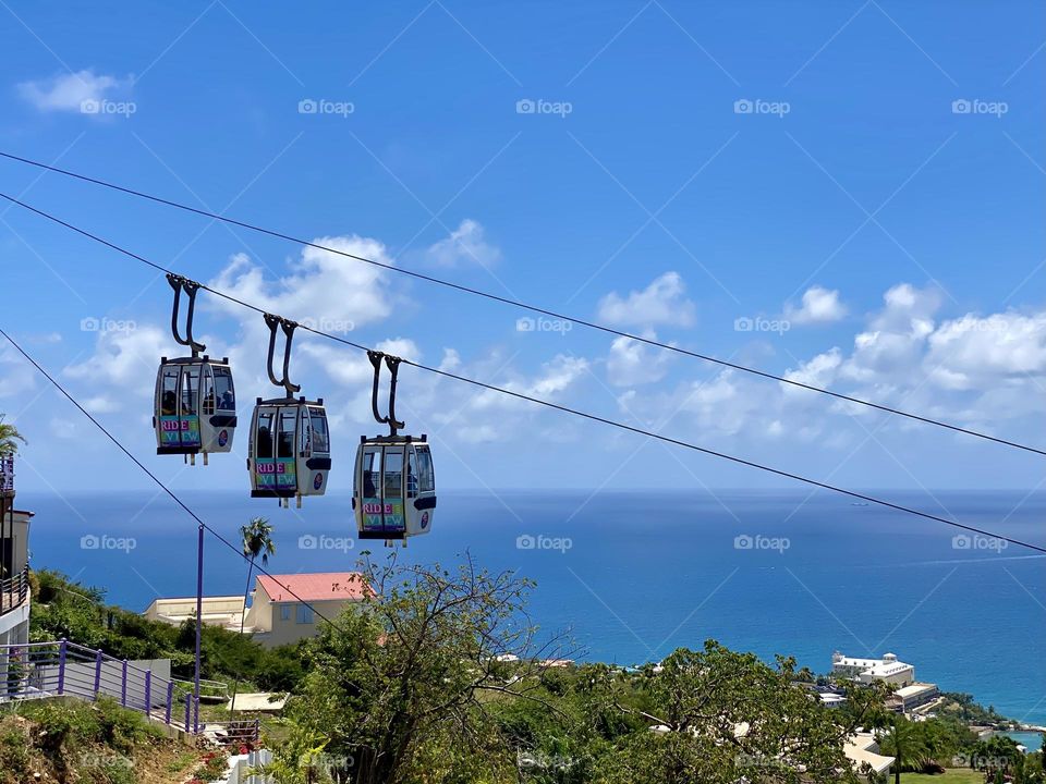 A trio of cable cars coming down from a mountain top viewpoint