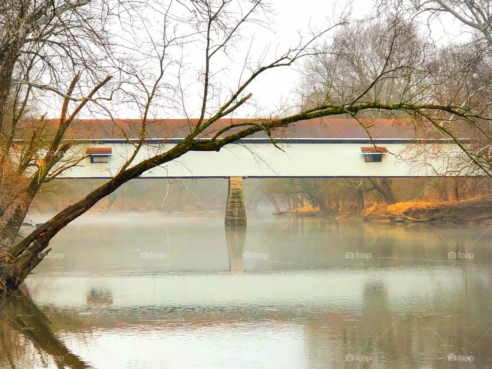 Old covered bridge on a foggy winter day on the river in Indiana 