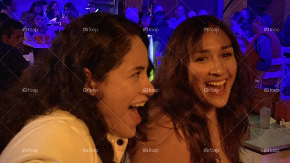 Friendship between two women laughing and enjoying the party during the midnight.