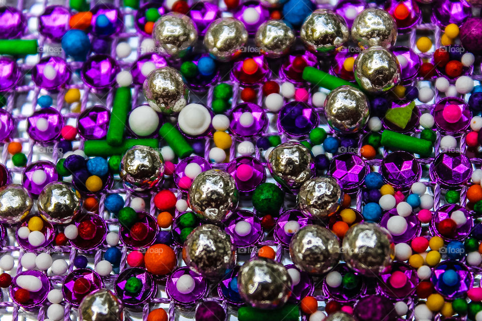 Clash of Colours: Multi-coloured candy sprinkles & silver candy dragees sitting on a purple gemstone net mesh over a mirror creates a multi-layered cornucopia of colour! 🌈