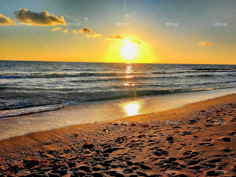 Enjoying an evening sitting in the sand at the beach watching the beautiful sunset on the ocean while listening to the waves roll in off the Gulf Coast in Florida.