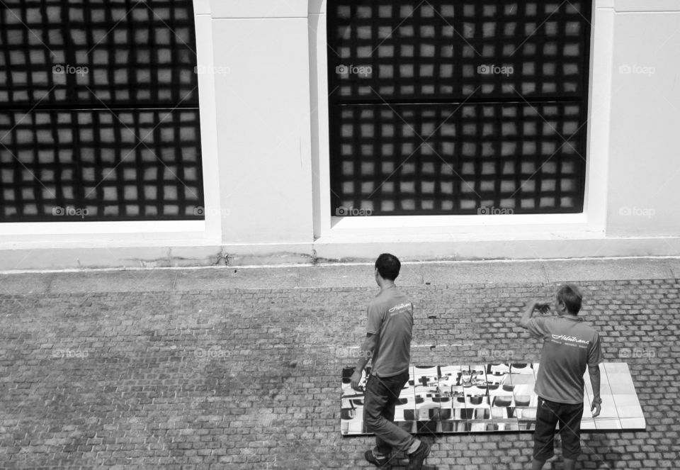 Two men working on a mural art