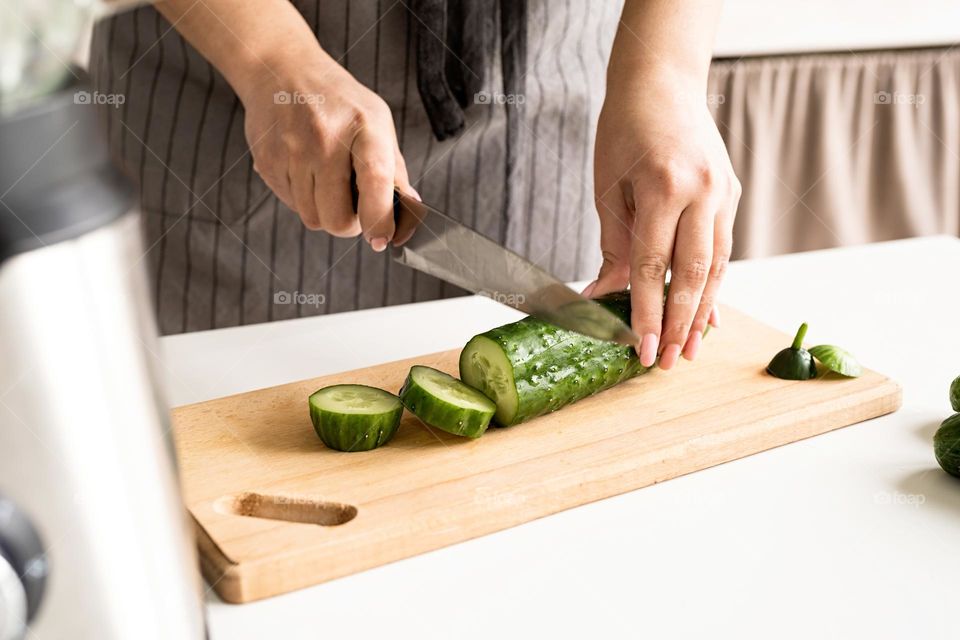 woman cutting cucumber