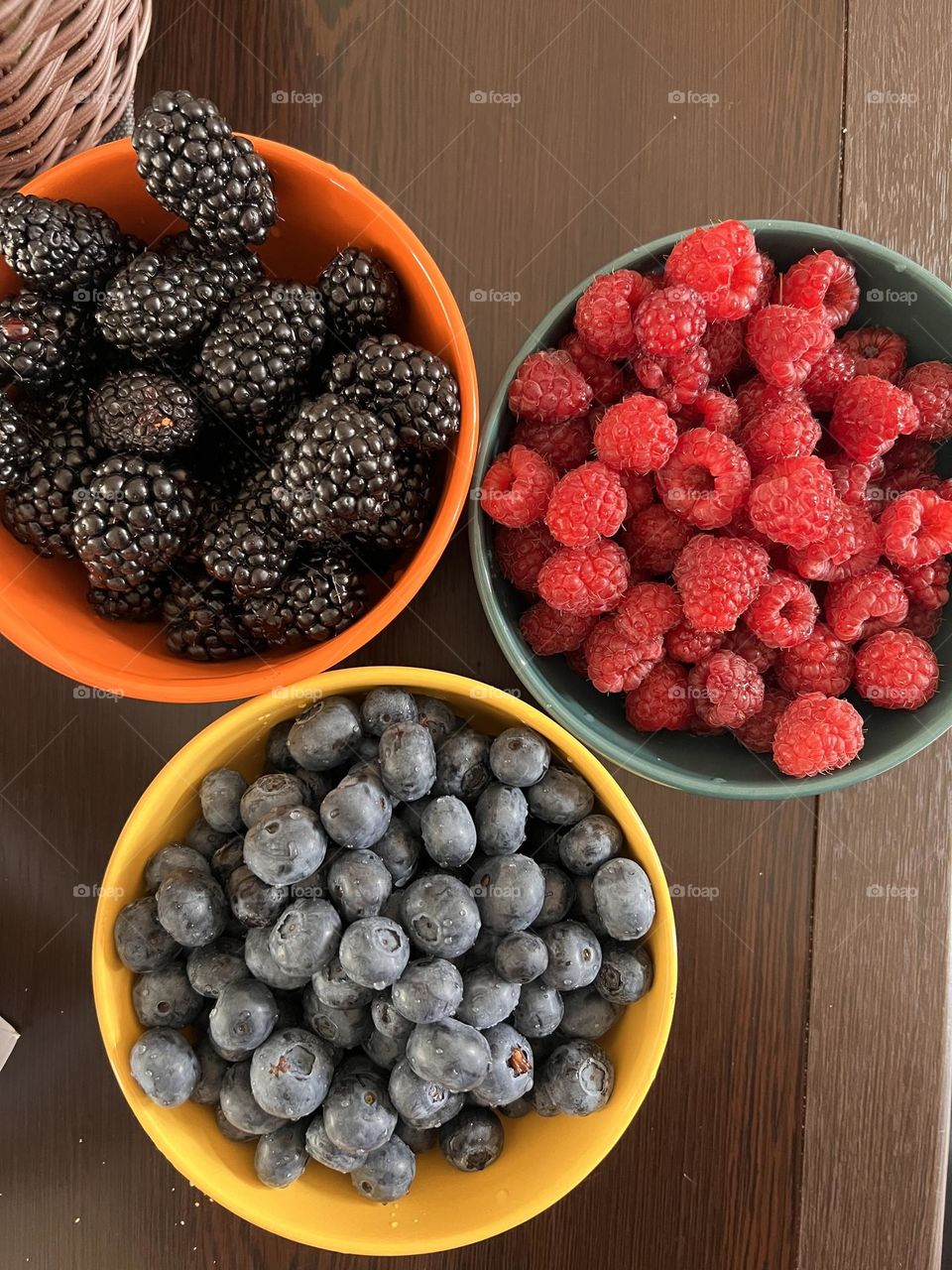 Colorful berries in three vibrant bowls – a summer snack