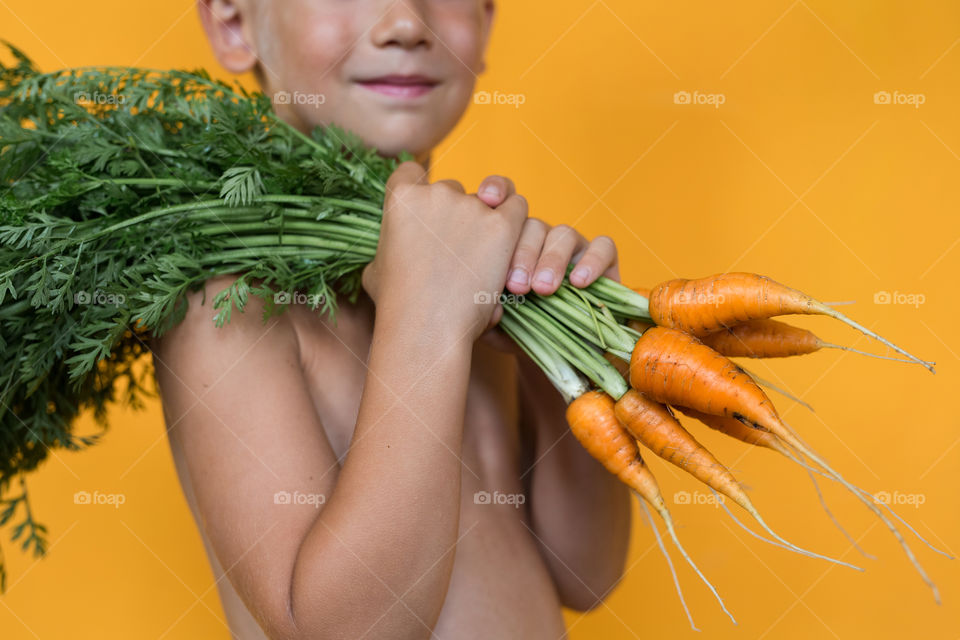 cute kid holding fresh carrot in hands, spring mood