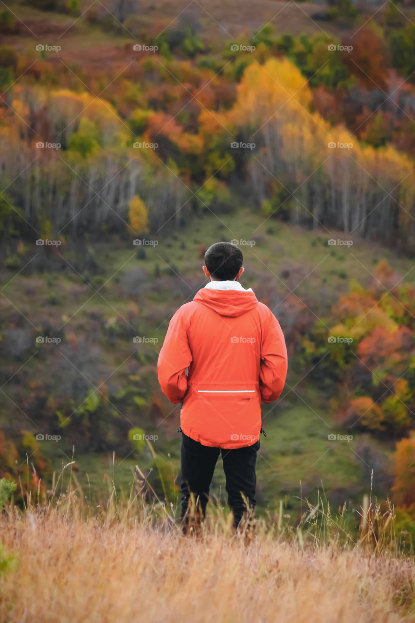 Rear view of man standing on field during autumn.