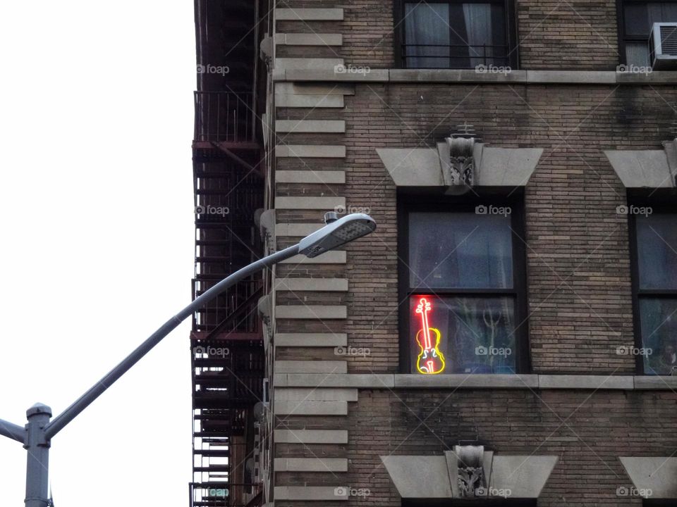 Electric neon guitar in the window