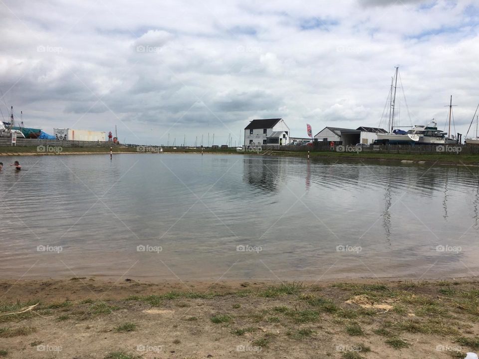 Natural salt pool Essex countryside reflection with boatyard in summer 
