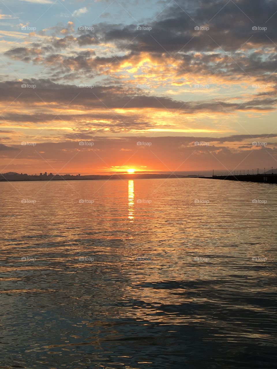 Gold getting dissolved in the water and dissipating in the sky. Sunsets by the water are beautiful! 