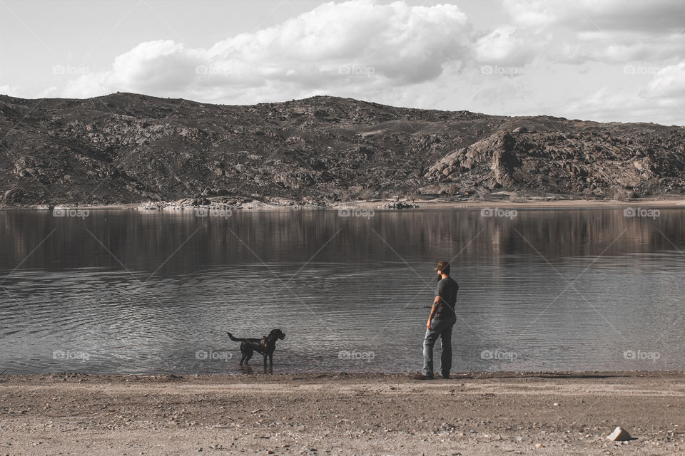 Dark tones moody lake playing with dog black lab pup water
