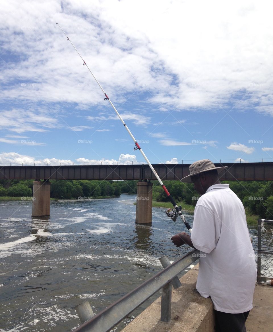 Great day for fishing . Man fishing at the river