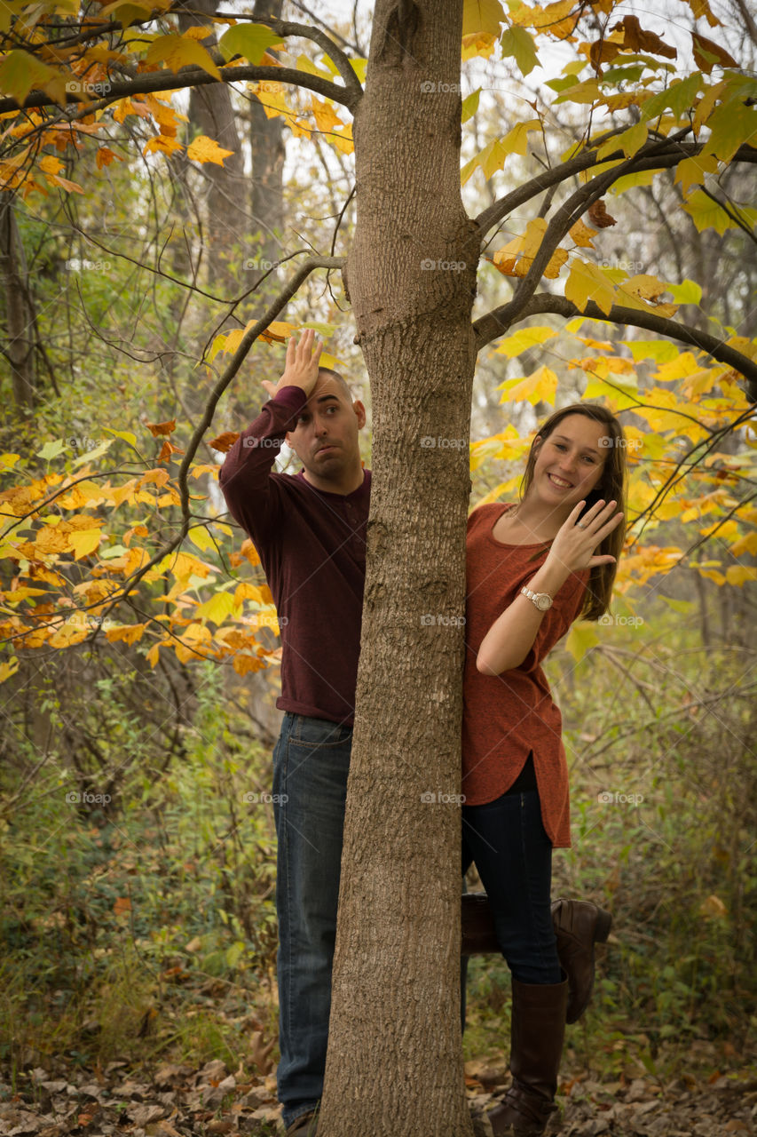 Portrait of couple standing behind the tree