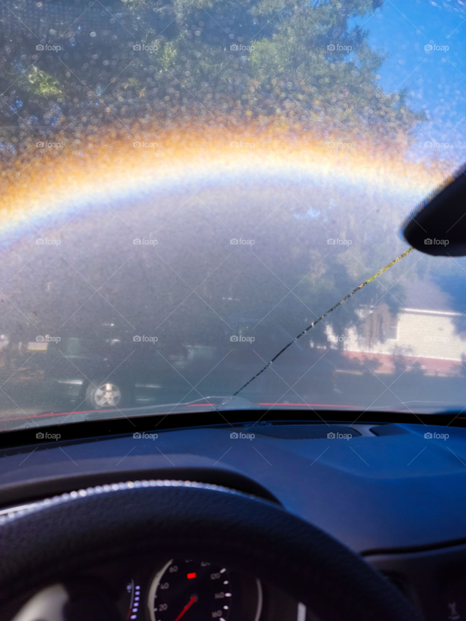 rainbow outside of my windshield this morning. made from the sun coming through the windows hitting the blind steering wheel cover and dew on the windshield