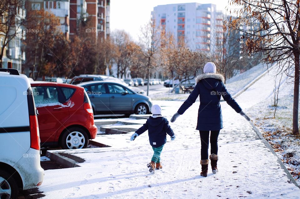 Child and mother dancing on snow