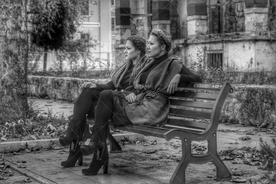 Two young woman sitting on bench