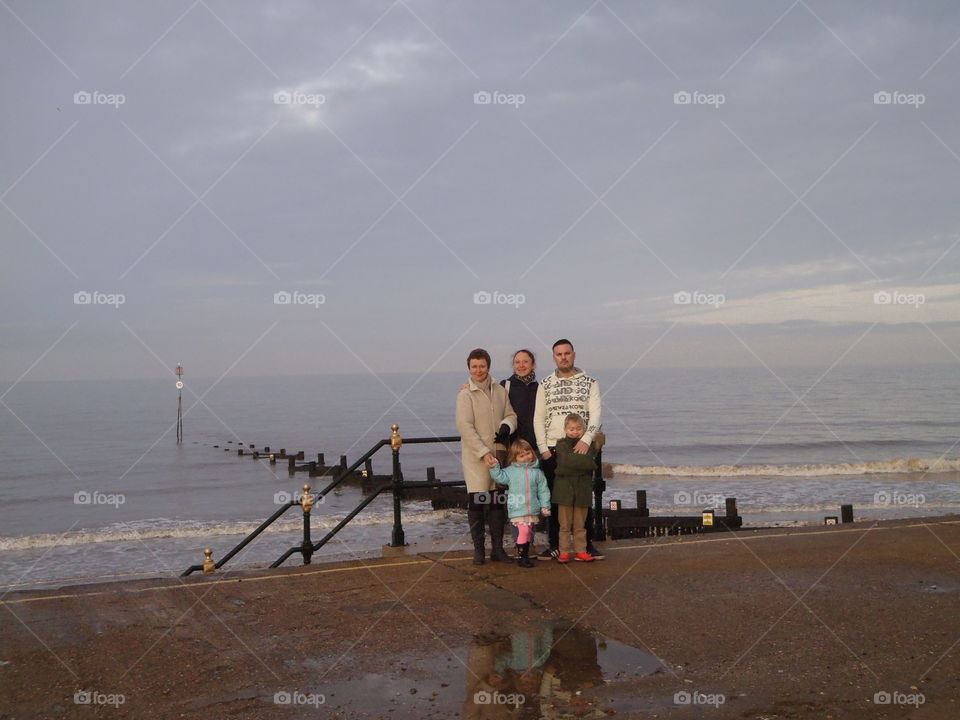 Happy family standing in front of sea