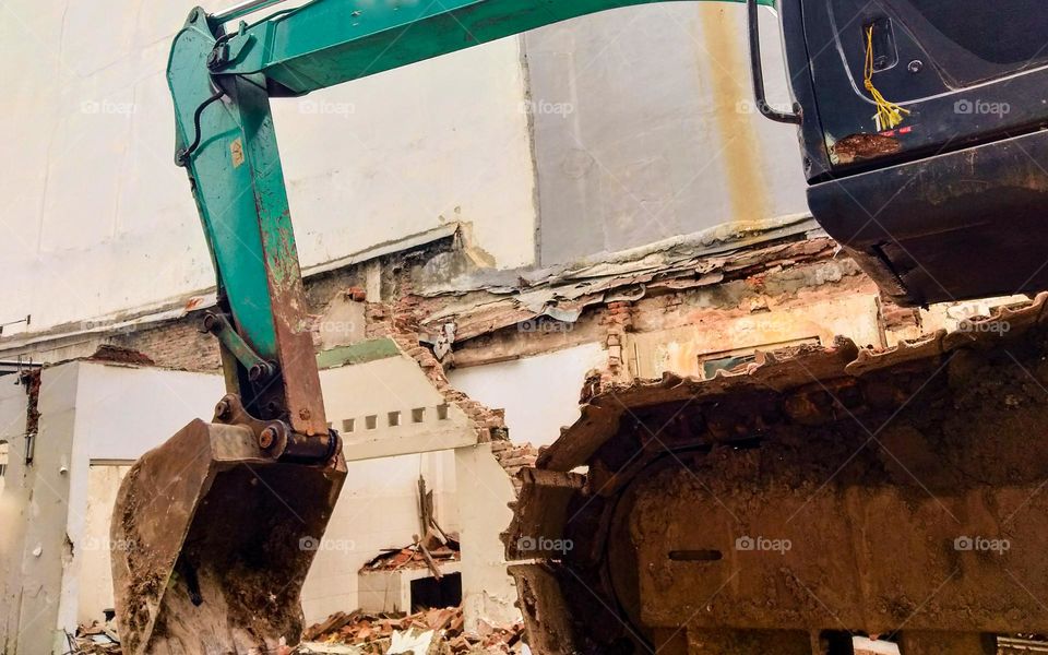 Photo of tractor or heavy vehicle destroying buildings