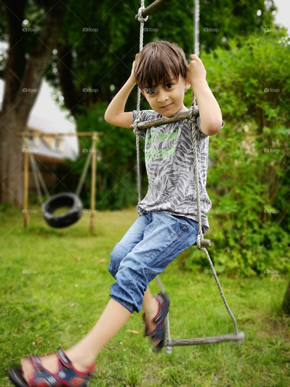 Cute boy on rope ladder