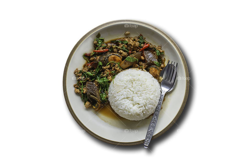 Stir fried basil leaf pork with rice and put the preserved egg on a white background with clipping path.