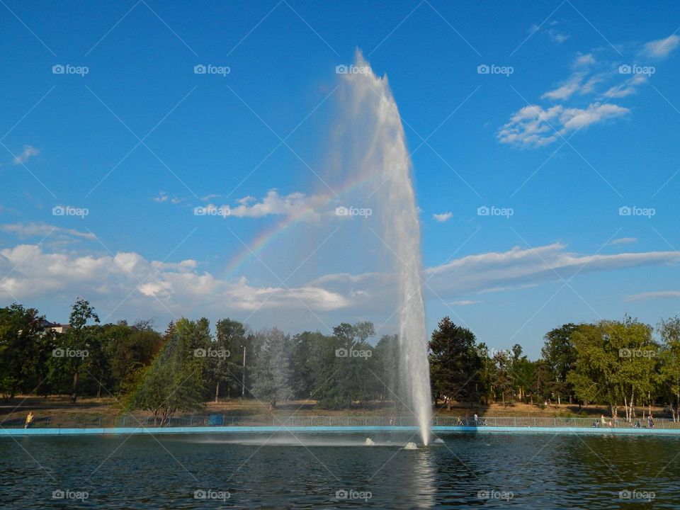 Fountain in park and rainbow 