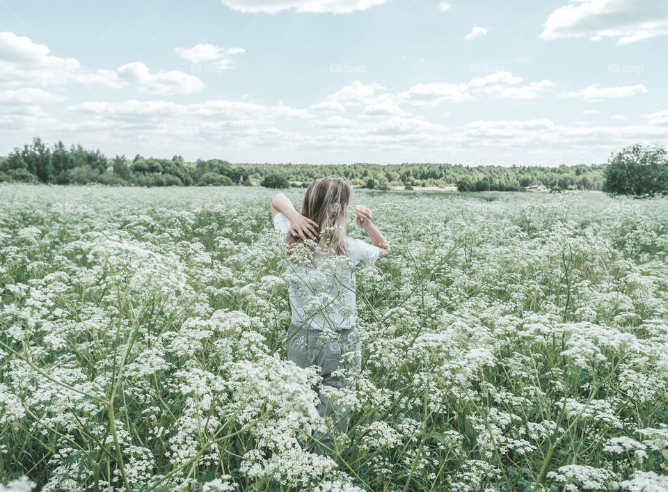 young woman in a white flower field, summer day