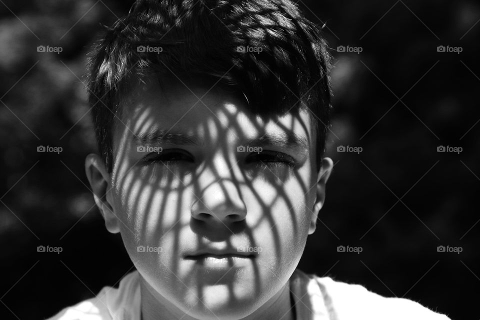 Sun shines through plate creating design on face of boy