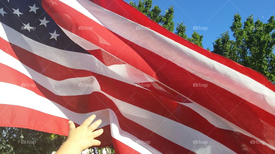 boys hand (the new generation) reaching for the USA flag