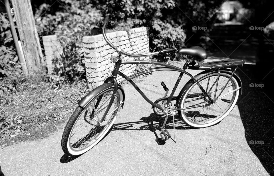 cruiser bike by brick wall in city driveway one lonely bicycle mission cruiser white walls cruiser bike