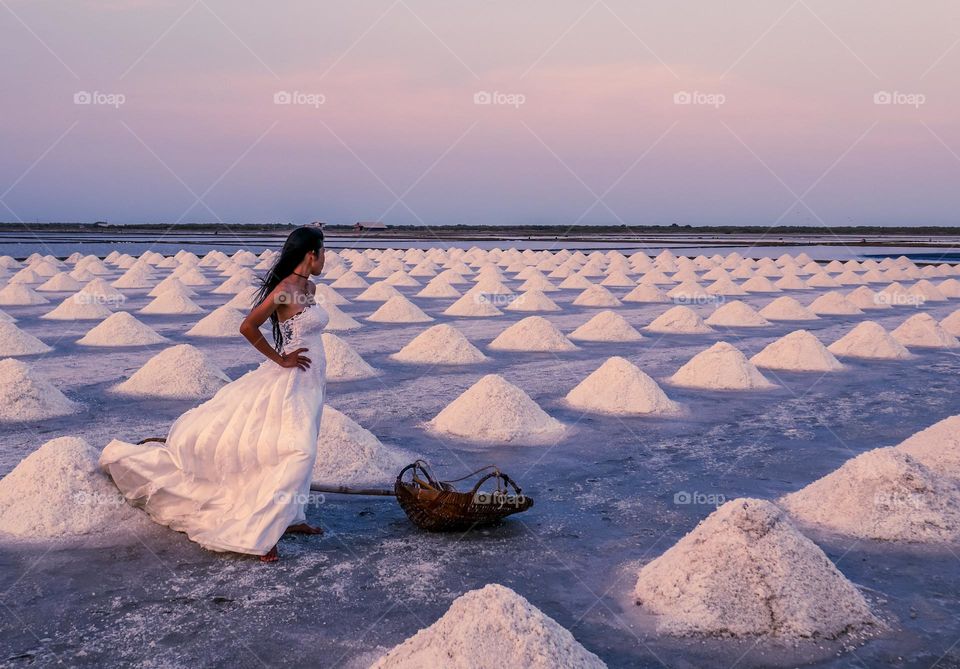 Pretty bride with white dress standing in salt marsh